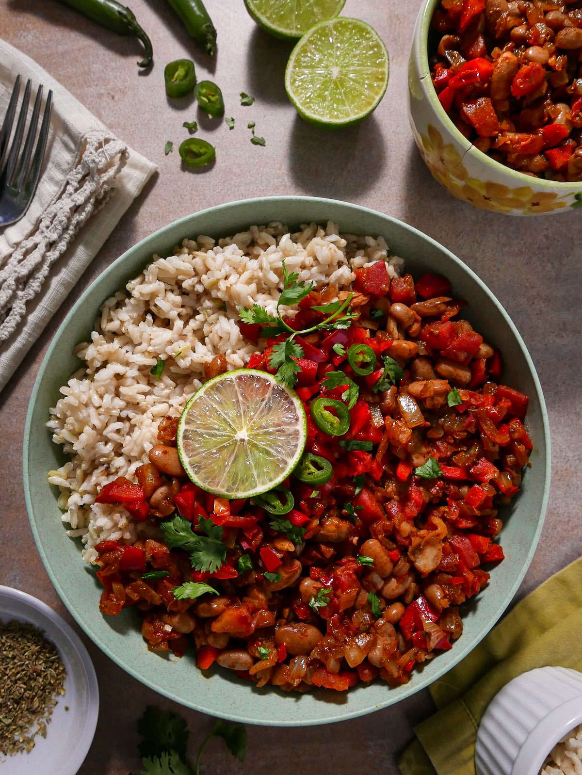 Healthy beans and rice garnished with fresh lime, cilantro, and jalapeños.