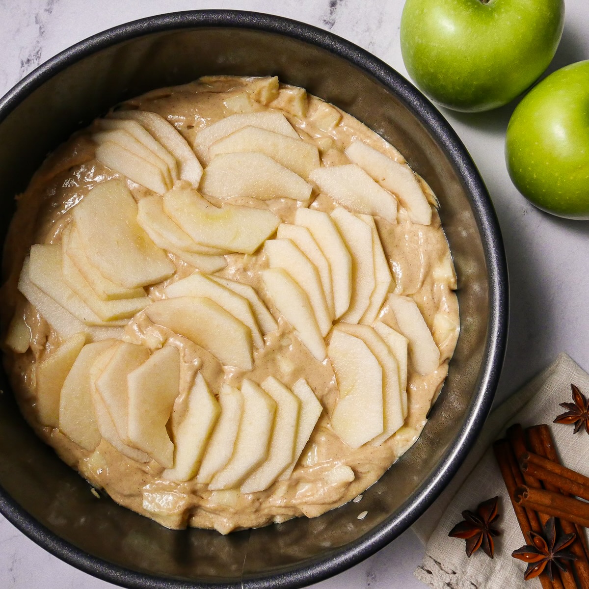 Apple slices arranged on top of cake batter.