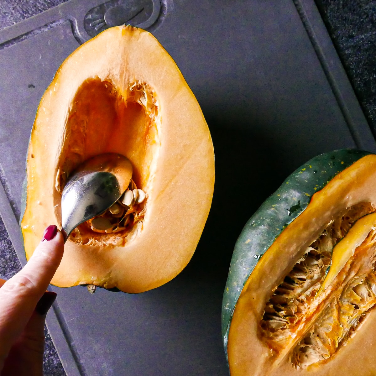 Removing seeds from acorn squash. 