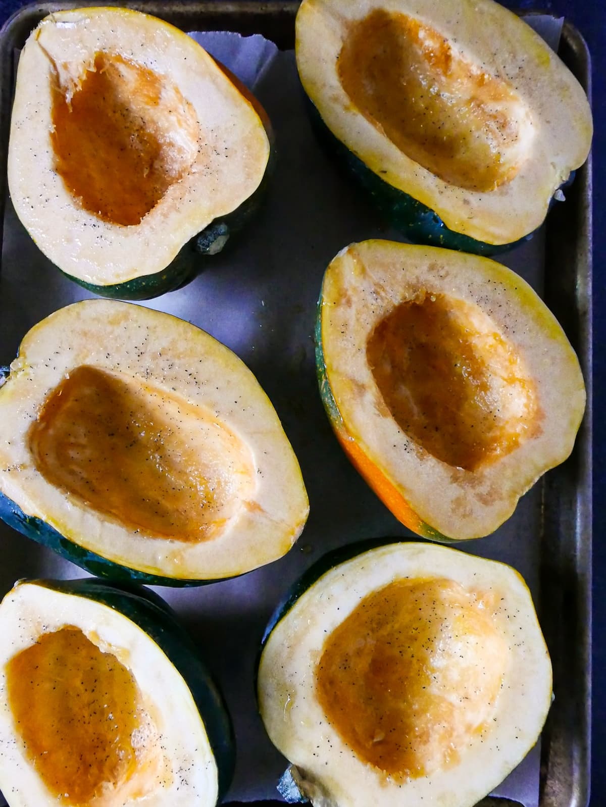 Scooped out acorn halves drizzled with olive oil.