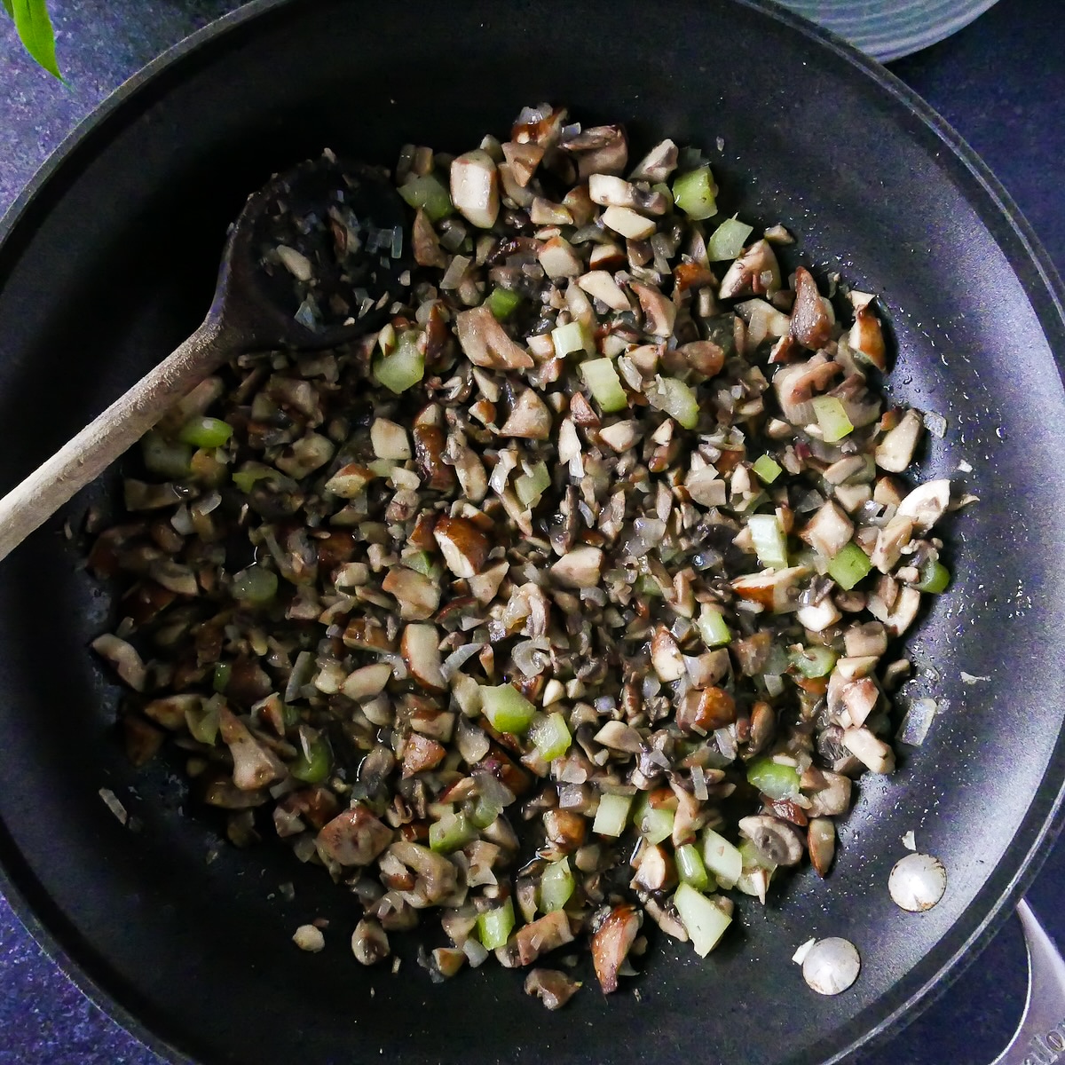 Mushrooms, celery, and shallots cooking in a pan.