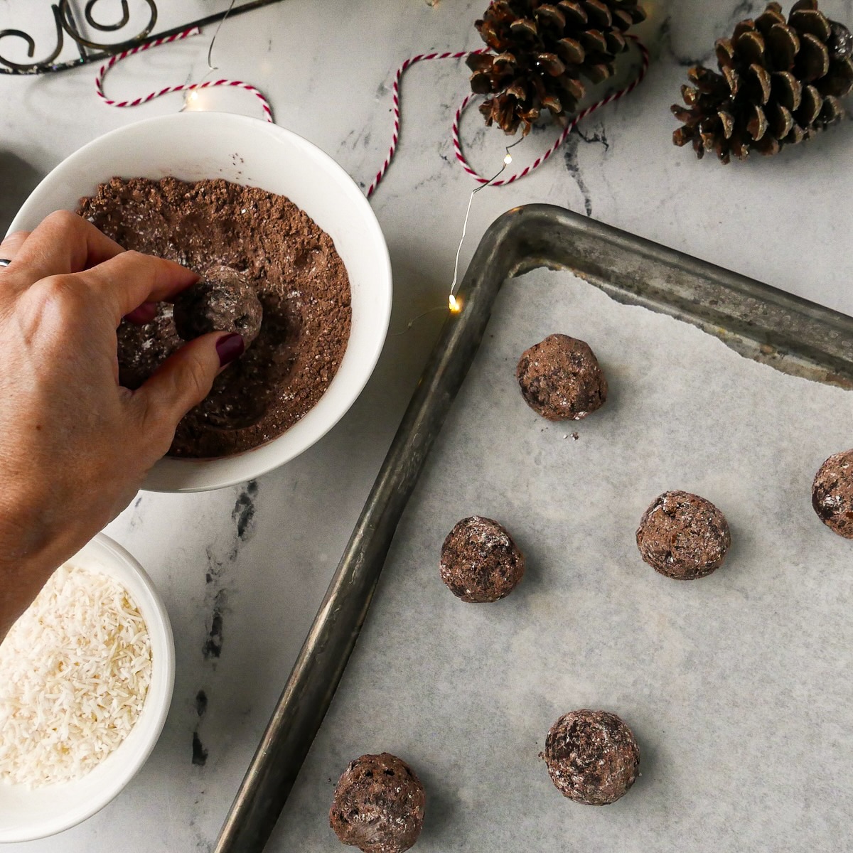 rolling-cookie-balls.jpg Rolling cookie balls into powdered sugar mixture.