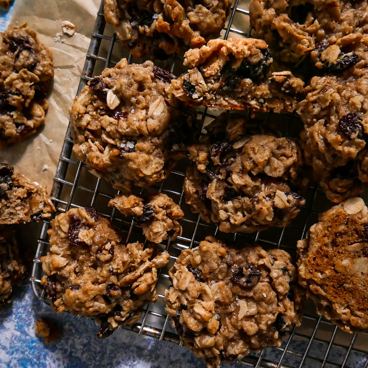 Freshly baked chewy oatmeal raisin cookies on a cooling rack.