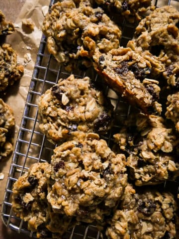 Homemade vegan cookies with oatmeal and raisin on a cooling rack.