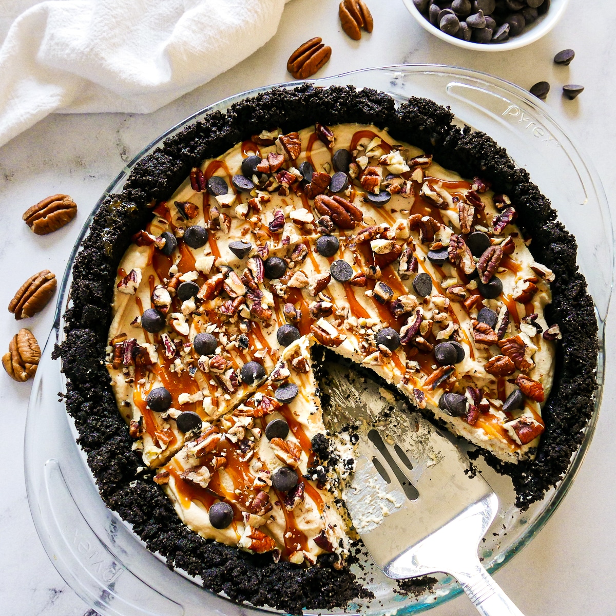 Sliced chocolate caramel pie with pie server. 