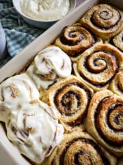 pan of fluffy cinnamon rolls with cup of coffee on the side.