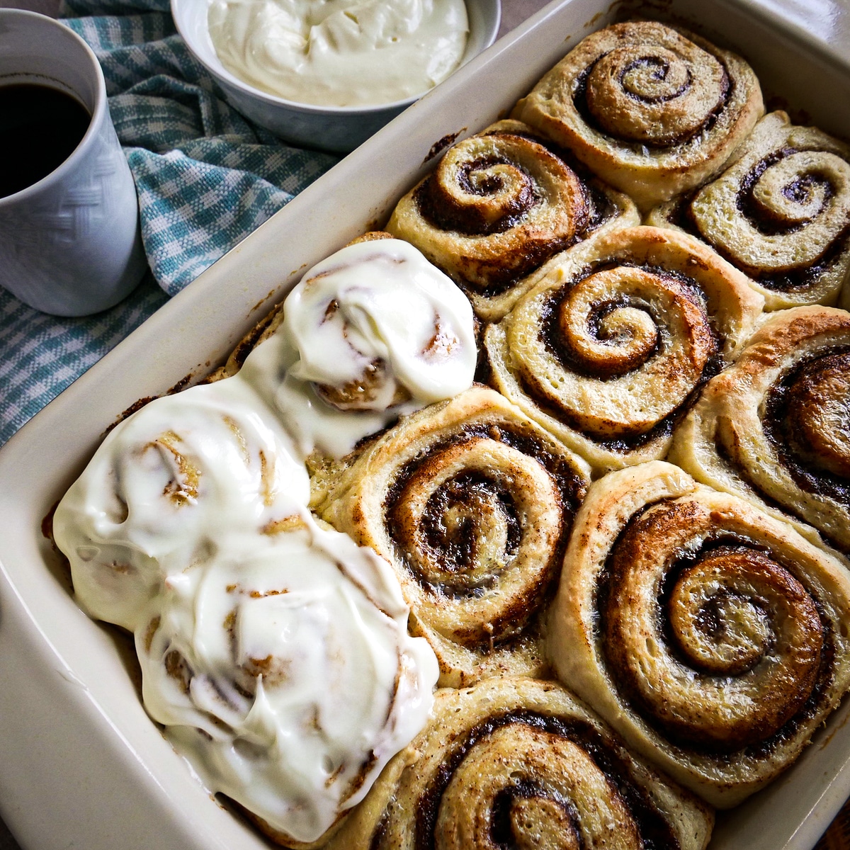 fluffy-cinnamon-rolls.jpg pan of fluffy cinnamon rolls with cup of coffee on the side.