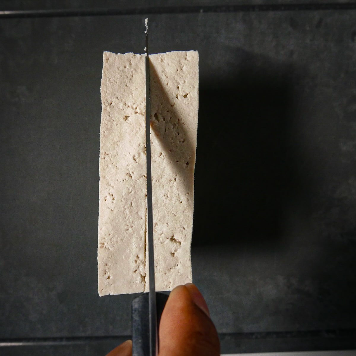 slicing-tofu.jpg Slicing drained and pressed tofu lengthwise.