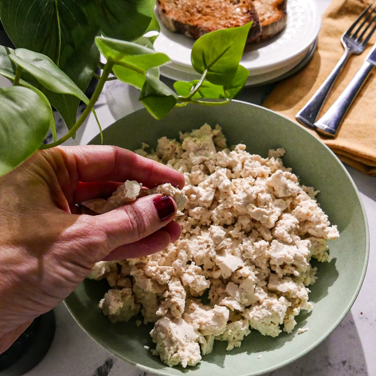 Breaking up tofu into small pieces. 