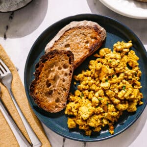 Tofu scrambled eggs served with toast on a plate.