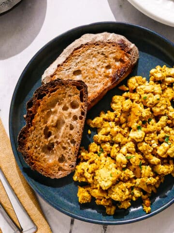 Tofu scrambled eggs served with toast on a plate.