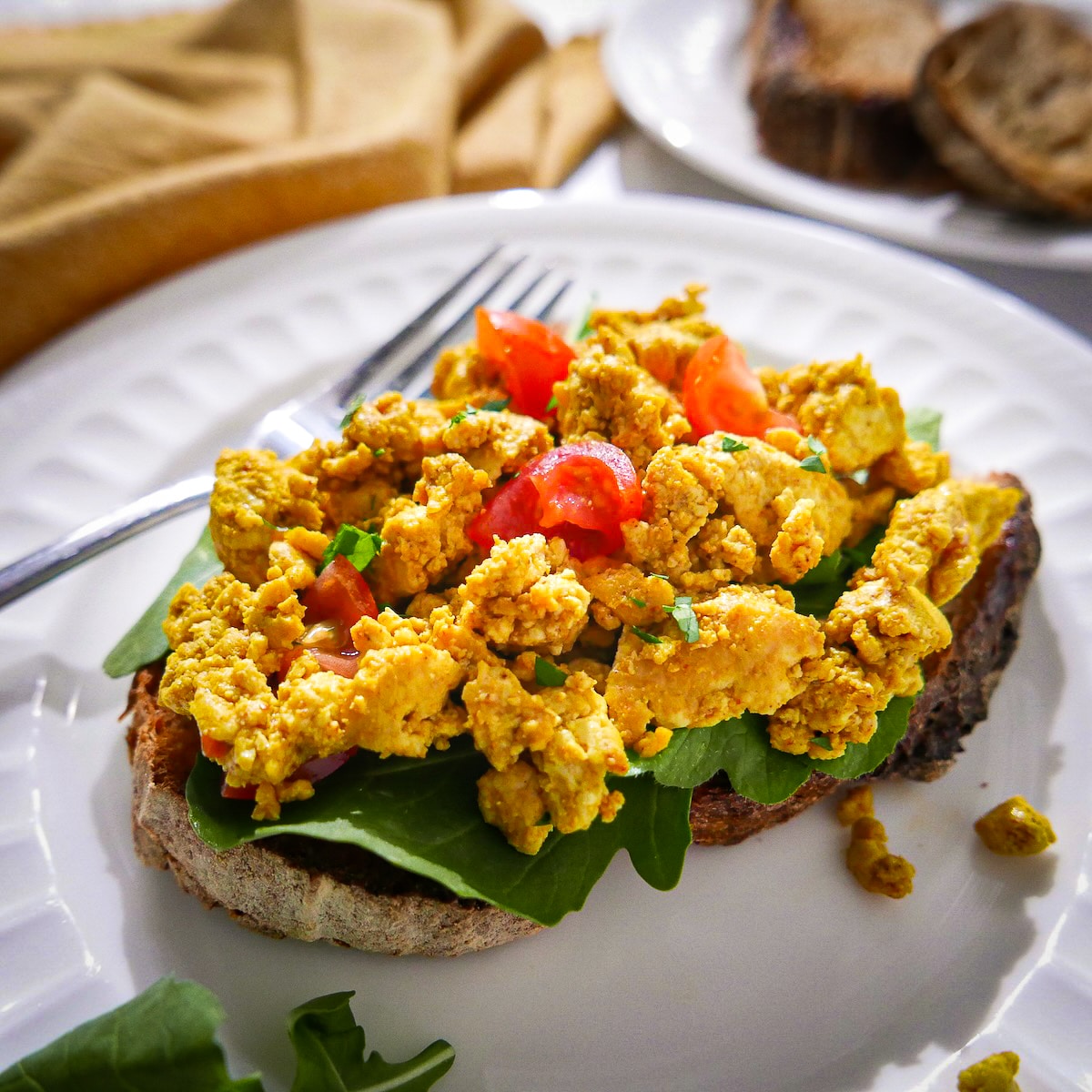 Scrambled tofu on toast with tomatoes. 
