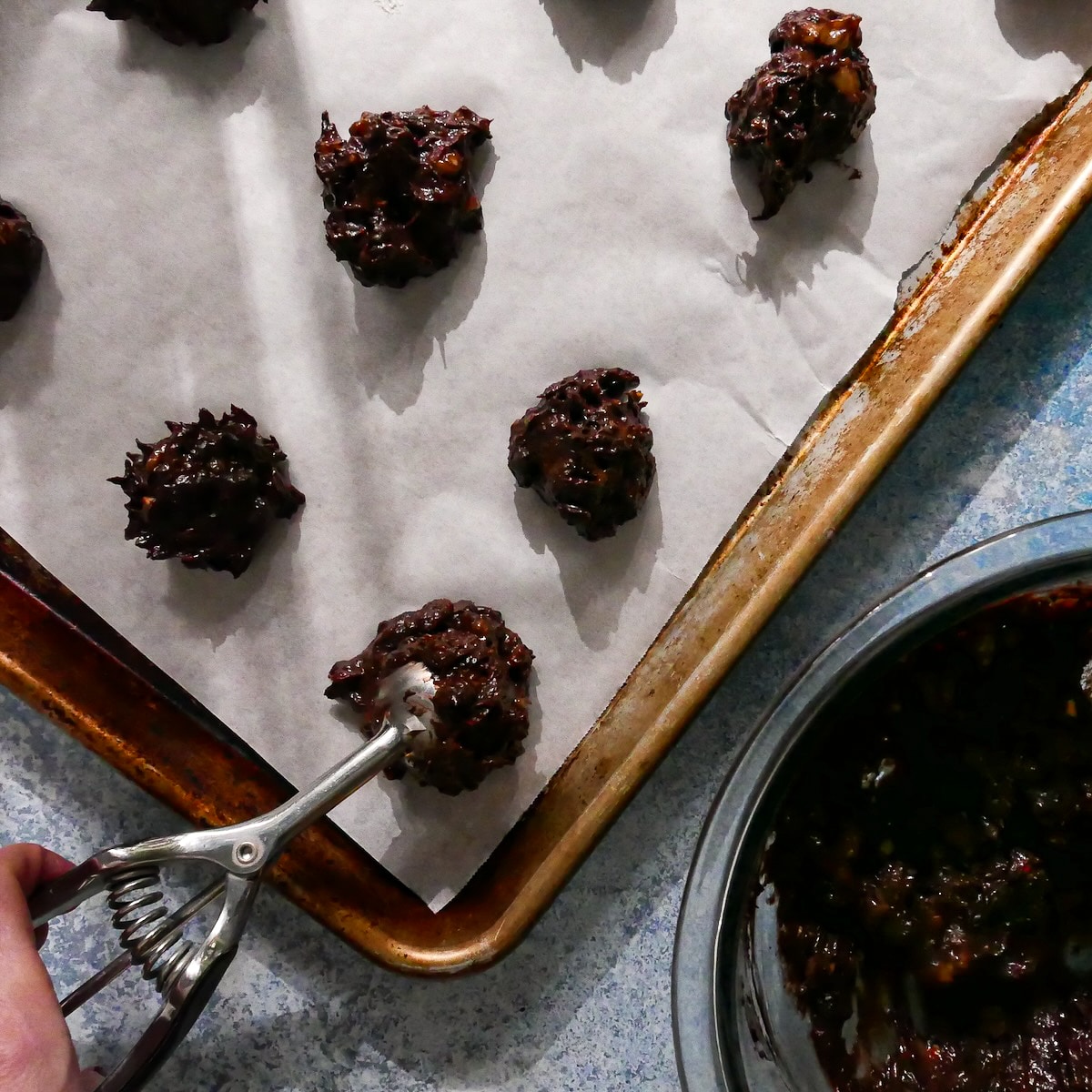 Cookie dough scooped onto a baking sheet.