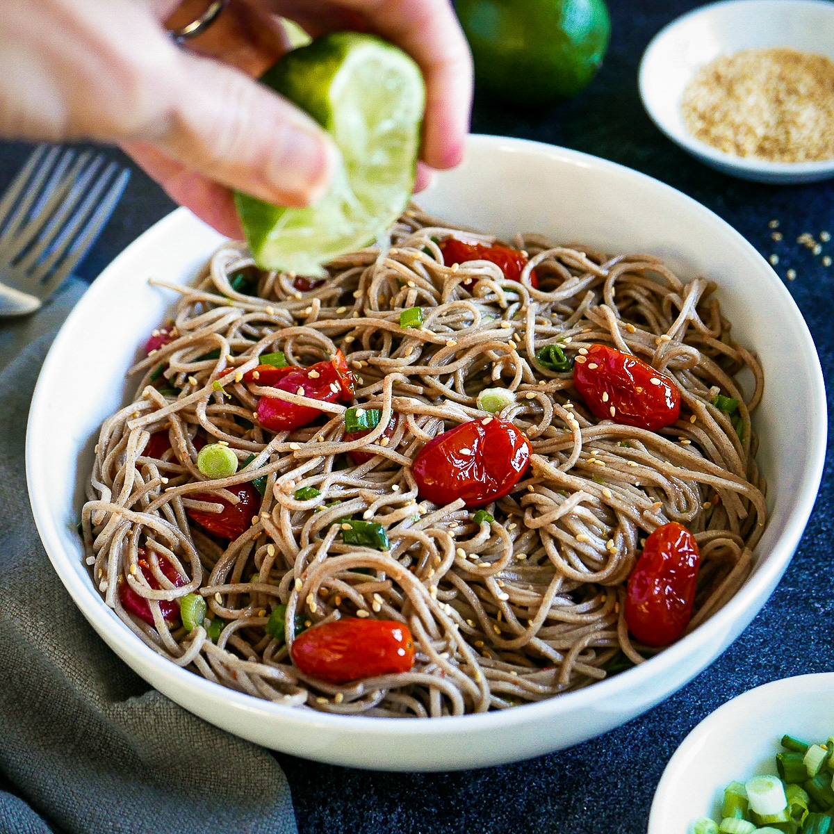 Squeezing lime over bowl of Asian noodles with miso.