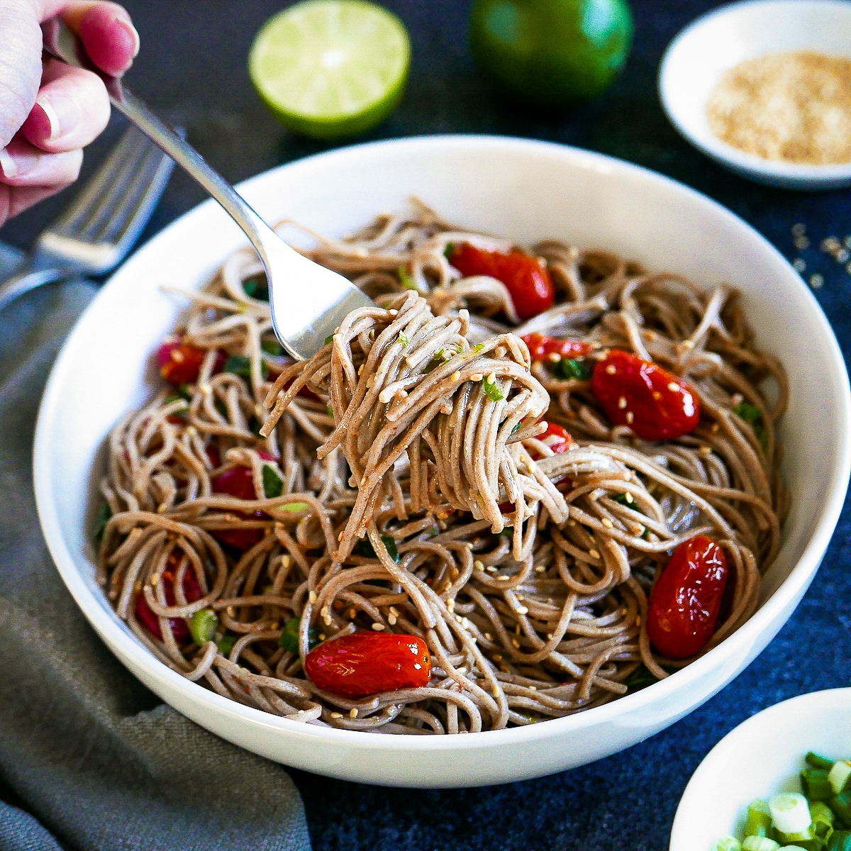 fork lifting bite of miso pasta out of a white bowl.