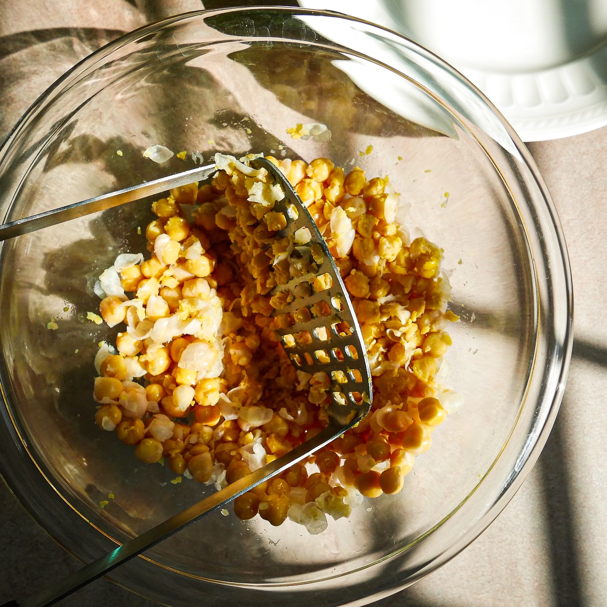 Bowl of smashed chickpeas in a mixing bowl.