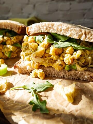 Chickpea salad sandwich arranged on a cutting board.