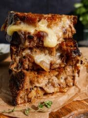 Gooey caramelized onion grilled cheese on a cutting board.