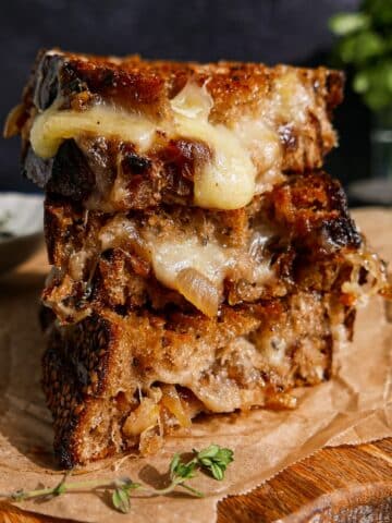 Gooey caramelized onion grilled cheese on a cutting board.