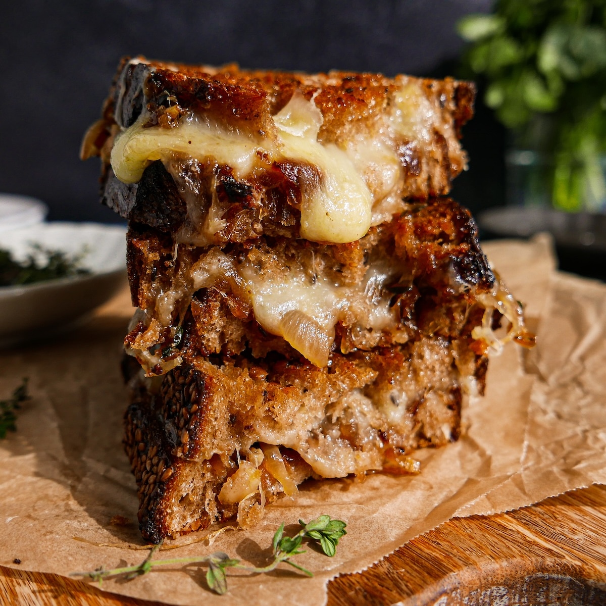 Gooey caramelized onion grilled cheese on a cutting board.