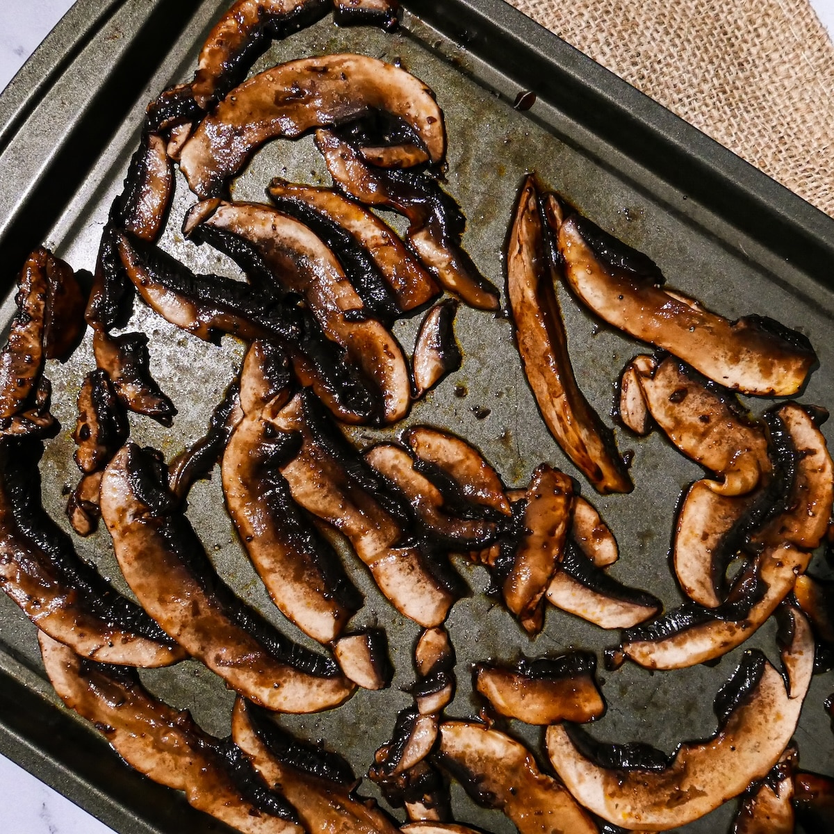 mushrooms-on-baking-sheet.jpg Sliced mushrooms spread out onto baking sheet.