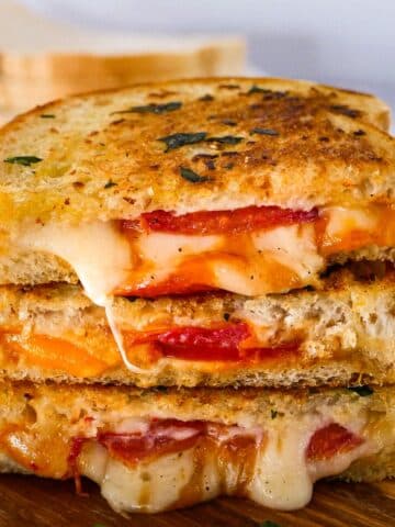 Cheesy garlic grilled cheese with tomato slices.