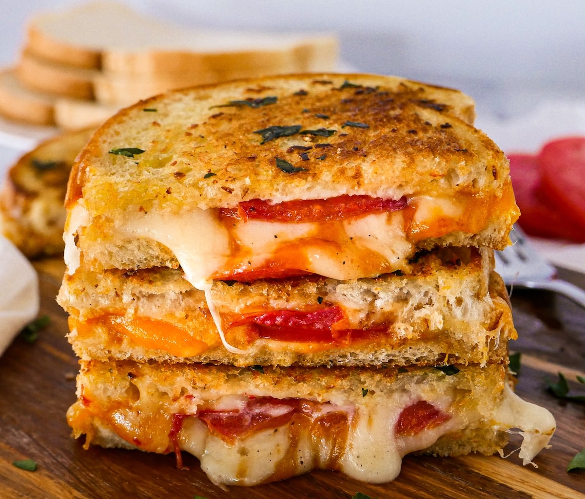 Cheesy garlic grilled cheese with tomato slices.