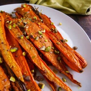 Caramelized maple roasted carrots over spiced yogurt, topped with pistachios and parsley.