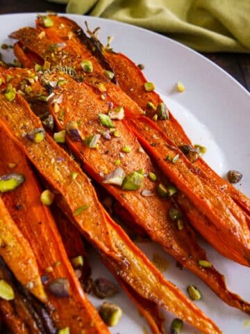 Caramelized maple roasted carrots over spiced yogurt, topped with pistachios and parsley.