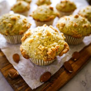 Fluffy almond poppy seed muffins on parchment.