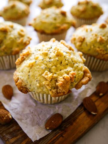 Fluffy almond poppy seed muffins on parchment.