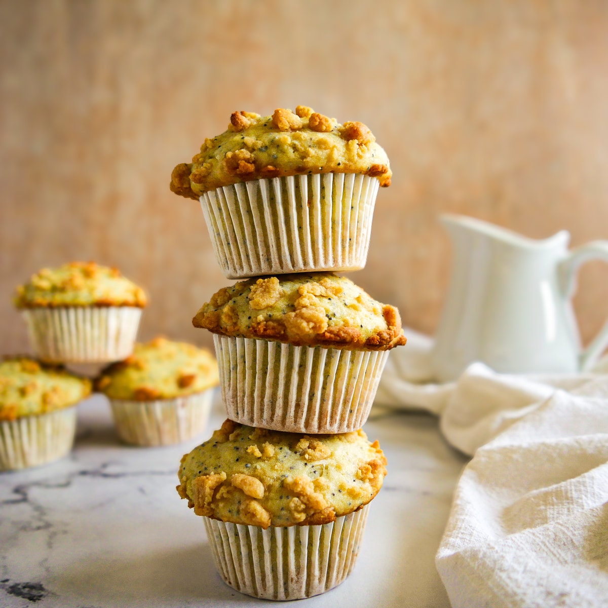 three-stacked-muffins.jpg three stacked poppy seed muffins on a table.