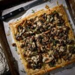 Buttery mushroom puff pastry tart cut into slices.