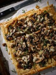 Buttery mushroom puff pastry tart cut into slices.