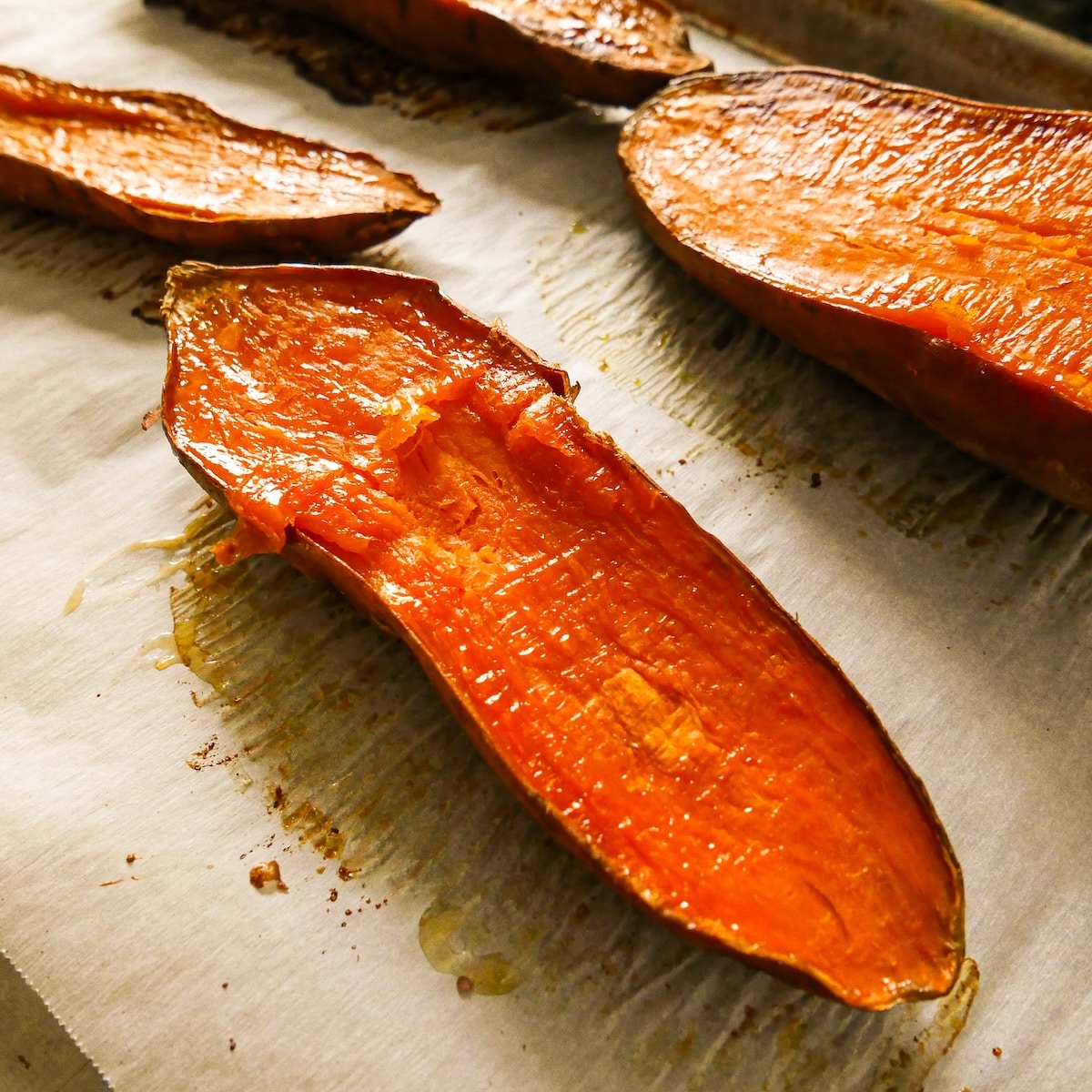roasted-sweet-potatoes.jpg Halved and roasted sweet potatoes on a baking sheet.