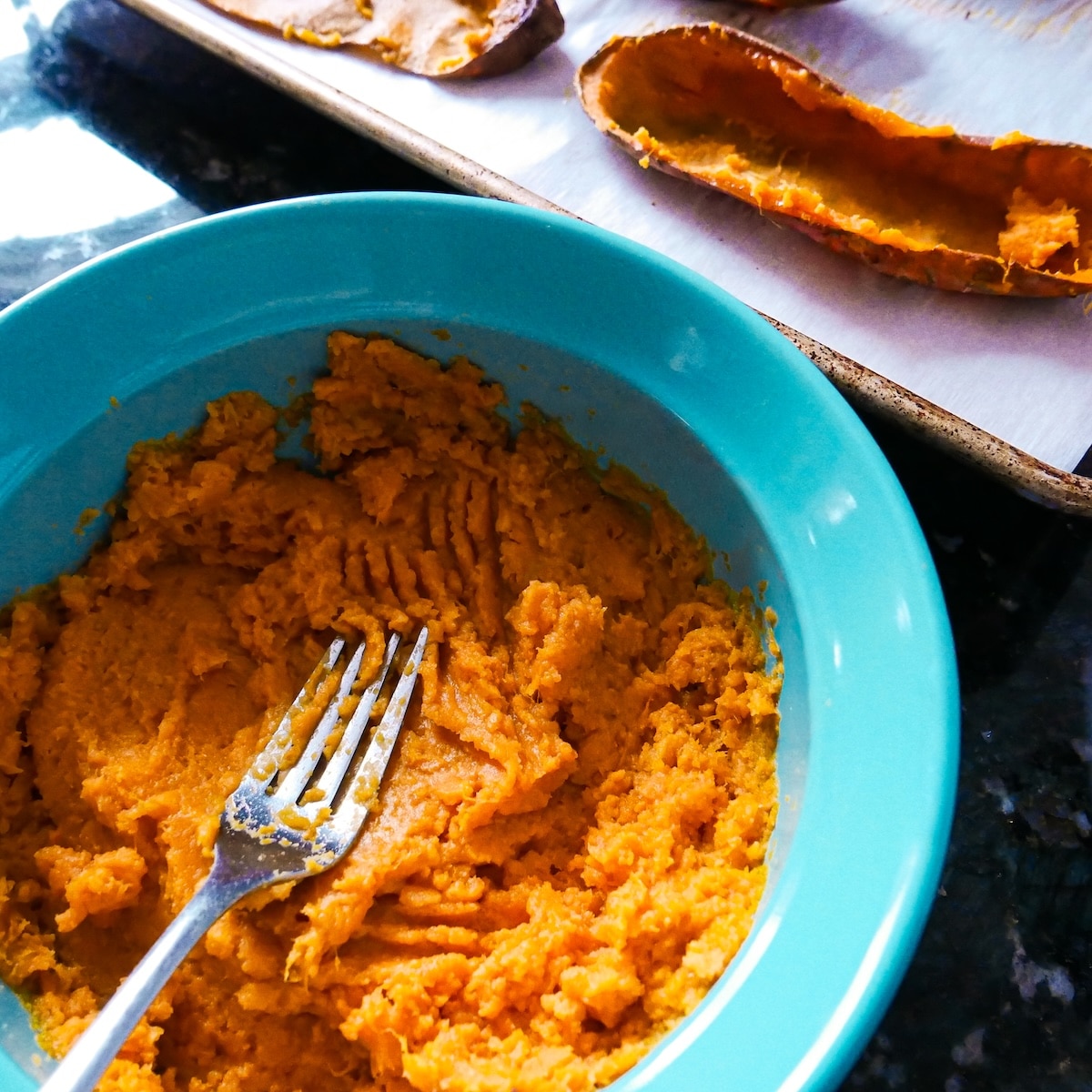mashed-sweet-potatoes.jpg Scooped out roasted sweet potatoes with flesh mashed in a bowl.
