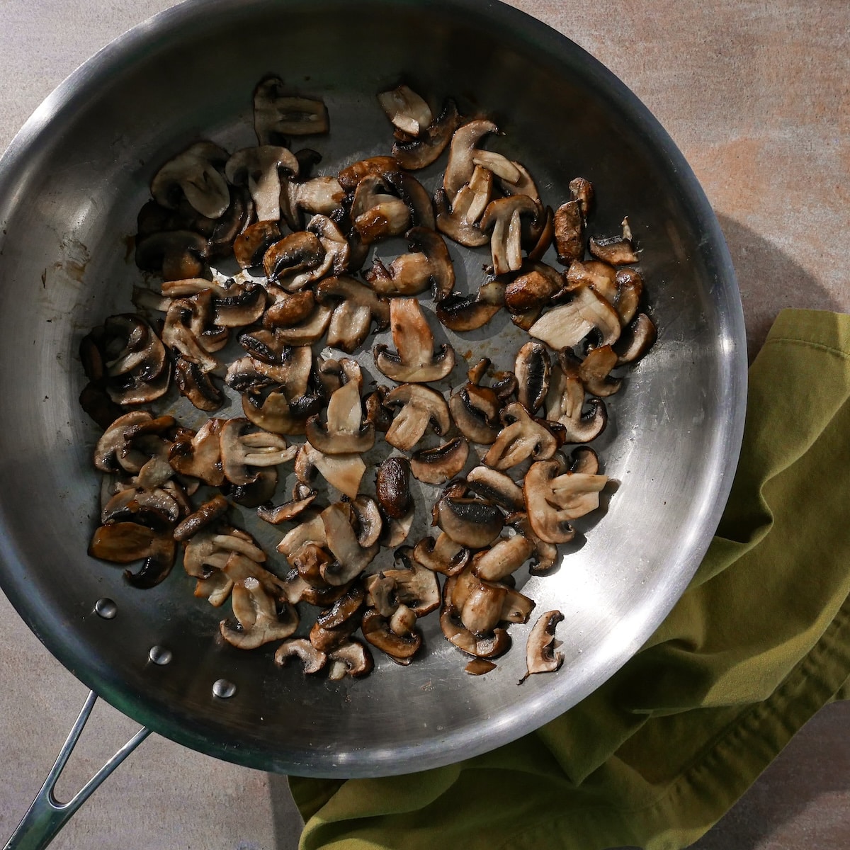 browning-mushrooms.jpg Browning mushrooms in a skillet.
