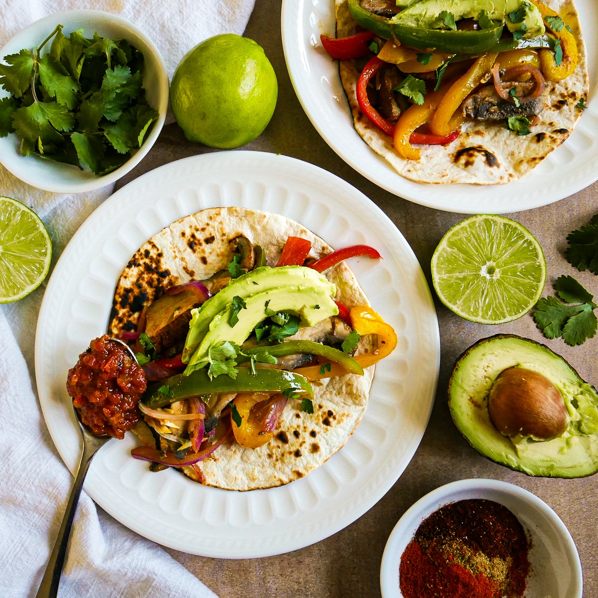 meatless-fajitas.jpg Meatless fajitas on plates with sliced limes and a spoonful of salsa resting on plate.