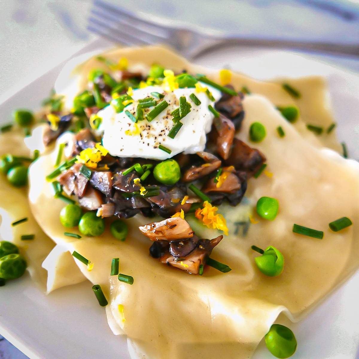 vegetarian-ravioli.jpg plate of wonton wrapper ravioli with peas and mushrooms.