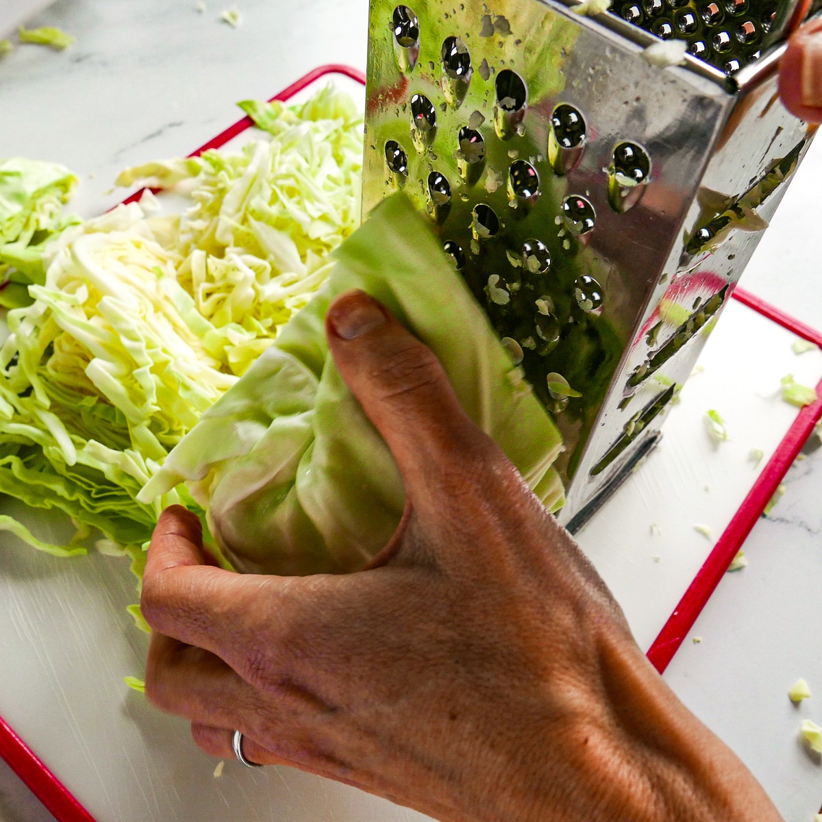 shredding-cabbage.jpg Hand shredding cabbage using a box grater.