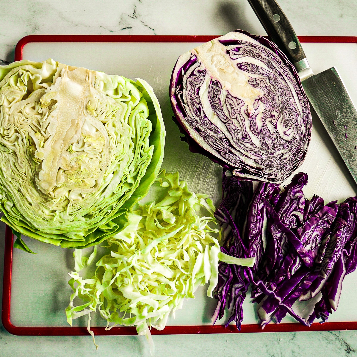 purple-and-green-cabbaage.jpg Two halves of green and purple cabbage resting on a cutting board.