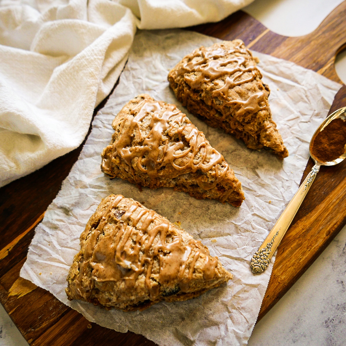 glazed-cinnamon-scones.jpg Glazed cinnamon scones arranged on a cutting board.