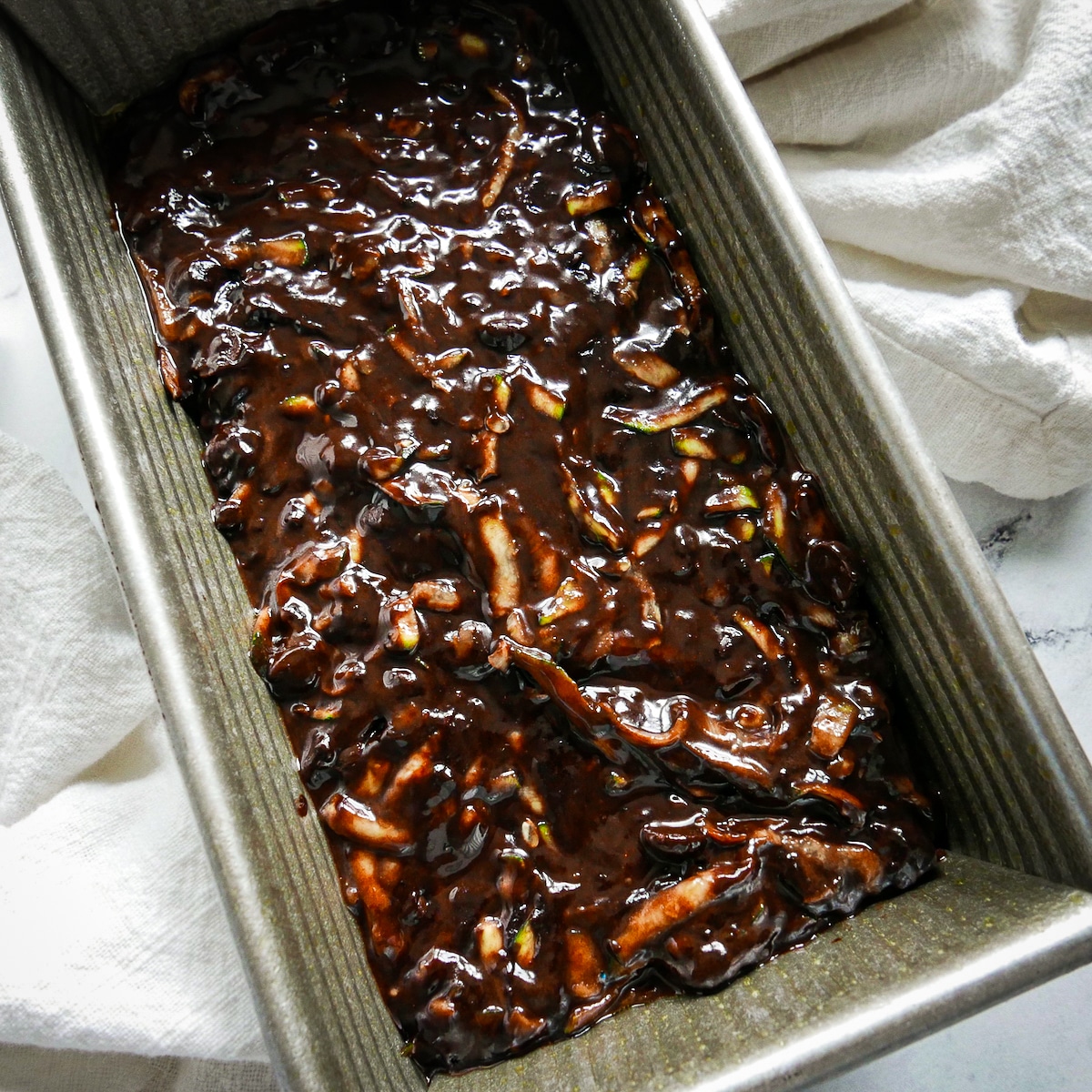 batter-in-loaf-pan.jpg Chocolate zucchini bread batter spread into prepared loaf pan.