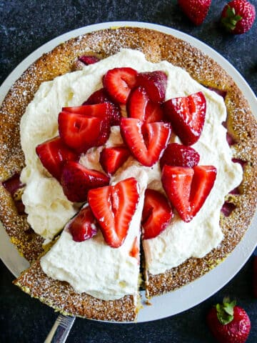 Strawberry vanilla cake with fresh strawberries and whipped cream.