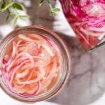 Refrigerator pickled onions in a glass jar.