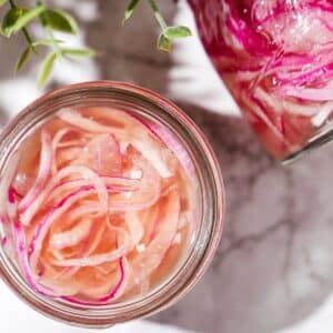 Refrigerator pickled onions in a glass jar.
