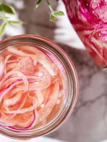 Refrigerator pickled onions in a glass jar.