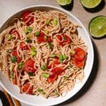Cold soba noodle salad with roasted tomatoes and scallions.