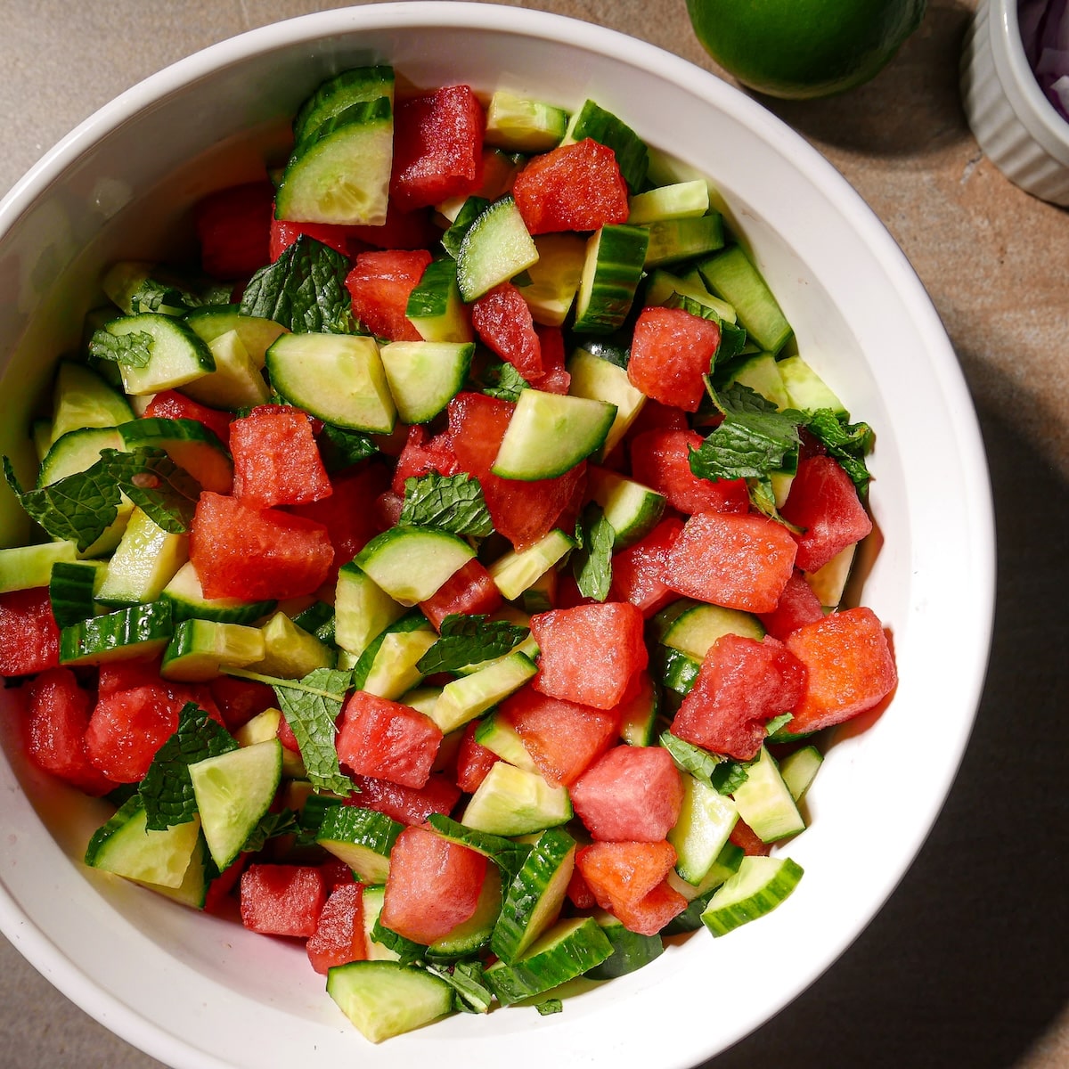 salad-produce.jpg Watermelon, cucumber, mint, red onion, and serrano pepper combined in a bowl.