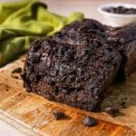 Double chocolate zucchini bread sliced with parchment paper.